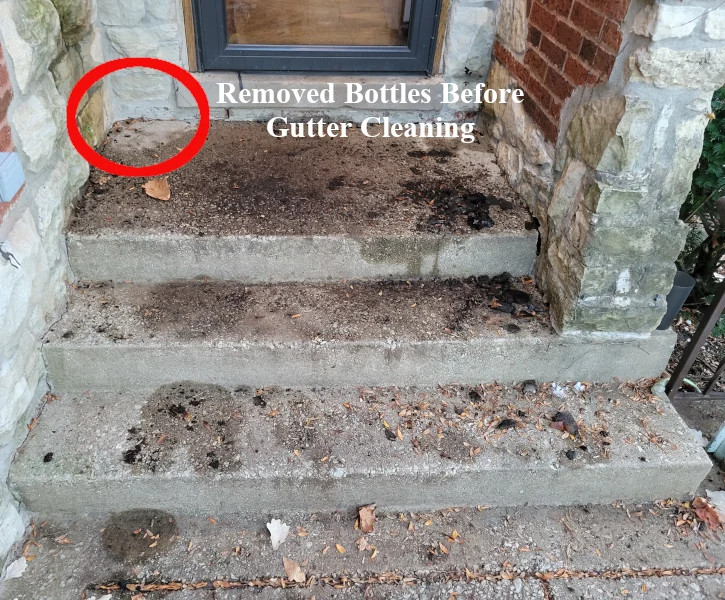 a front porch before pressure washing with mud and small leaves as a result of gutter cleaning services performed